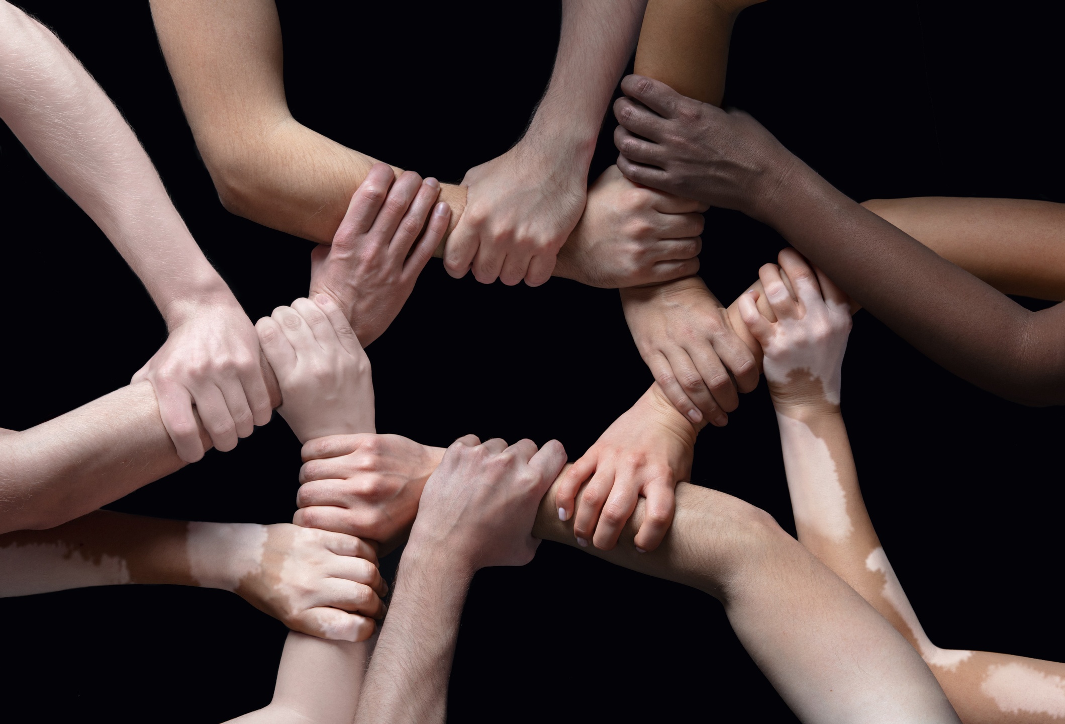 Hands of different people in touch isolated on black studio background. Concept of human relation, community, togetherness, inclusion